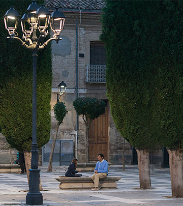 Mann og barn spiller kort på en gate i Palencia som er belyst med Philips Lighting