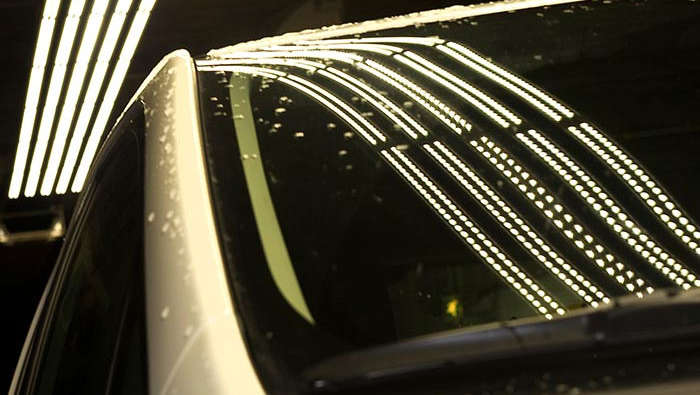 Tunnelbelysning som gjenspeiler seg i en bil 