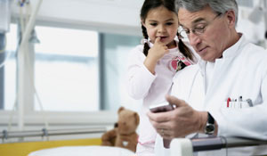 En lege og et barn under Philips-belysning, som skaper mer glede og produktivitet blant helsepersonell