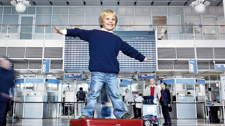 Et barn leker i en godt opplyst flyplassterminal