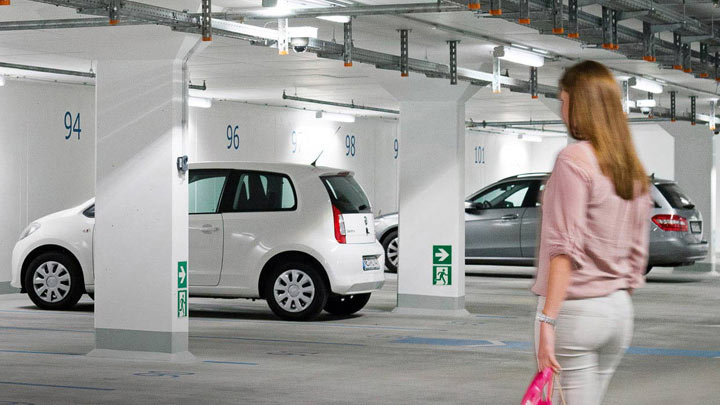 Kvinne går til bilen sin i et godt opplyst parkeringshus 