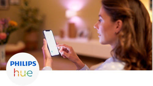 Kvinne styrer lysene i stua med smarttelefonen sin