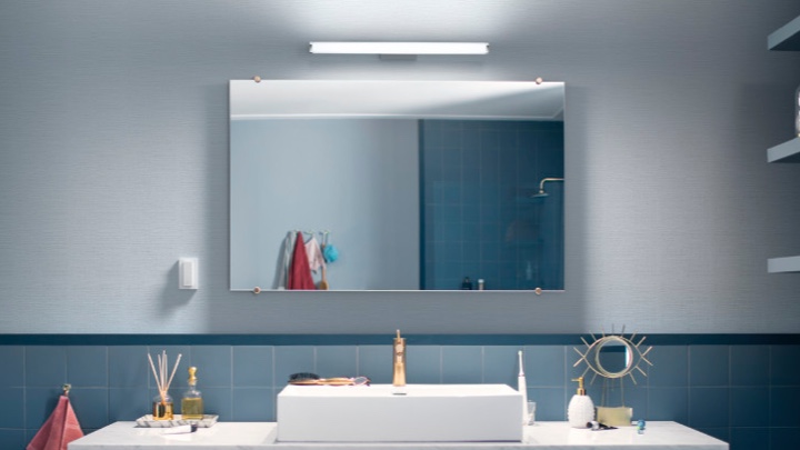 Vegglampe over et speil på badet