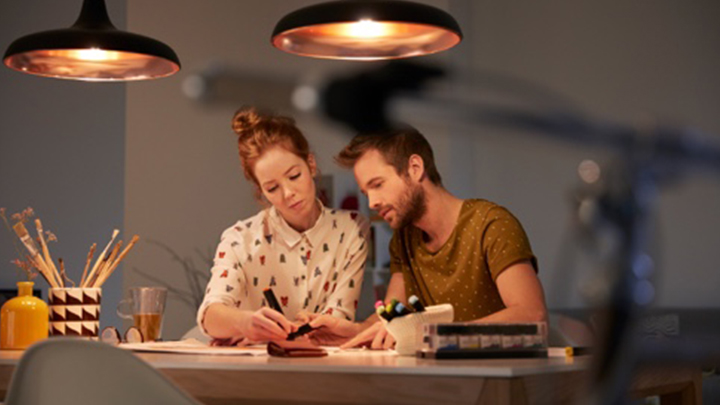 To mennesker lager en belysningsplan ved et godt opplyst skrivebord