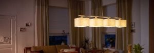 Moderne LED-pendellys med flere stoffskjermer lyser opp en koselig stue, og viser frem energieffektive og stilige belysningsløsninger for hjemmet for omgivende kveldskomfort.